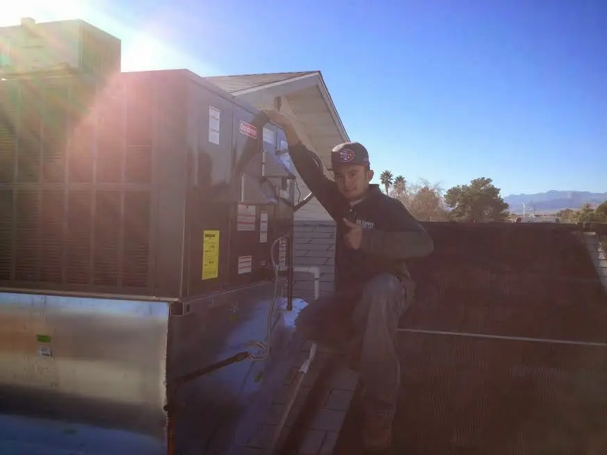 HVAC technician performing AC Tune-Up on a rooftop unit in Robeson